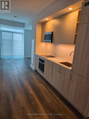 Vaughan (Vaughan Corporate Centre) condo for rent - A kitchen with wooden cabinets and a countertop.