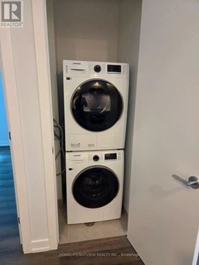 Vaughan (Vaughan Corporate Centre) condo for rent - A white dryer and washer are stacked on top of each other in a small laundry room.