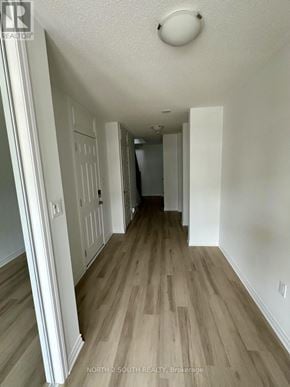 Barrie townhouse for rent - A hallway with wood floors and white walls.