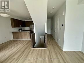 Barrie townhouse for rent - A kitchen with a refrigerator, sink, and cabinets is shown in a real estate listing.