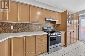 Brampton (Fletcher's Meadow) apartment for rent - A kitchen with brown cabinets and a tiled backsplash.