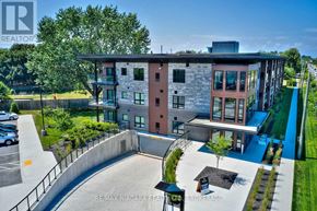 St. Catharines (Lakeport) condo for rent - A modern building with a parking lot in front.