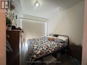 Toronto (Casa Loma) condo for rent - A bedroom with a bed, nightstand, and a wall with pictures.