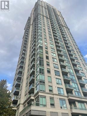 Mississauga (City Centre) condo for rent - A tall building with balconies and the words HOMELIFE MIRACLE REALITY OF LIFE at the bottom.