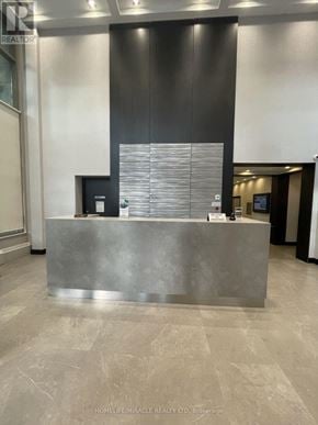 Mississauga (City Centre) condo for rent - A reception desk in a room with a grey floor and walls.