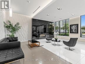 Toronto (York University Heights) condo for rent - A modern waiting room with a black leather couch and a wooden coffee table.