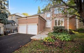 Mississauga (Sheridan) apartment for rent - A house with a driveway and garage doors.