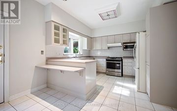 Mississauga (Sheridan) apartment for rent - A white kitchen with a stove top oven and microwave.