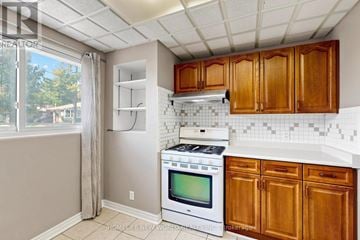 Newmarket (Bristol-London) apartment for rent - A kitchen with wooden cabinets and a white stove top oven.