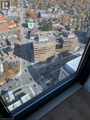 Kitchener condo for rent - A view from a high-rise building looking down at a street with cars and buildings.