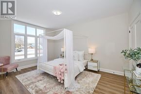 Fort Erie (Ridgeway) apartment for rent - A bedroom with a canopy bed and a pink chair.