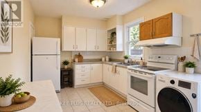 Toronto (Woodbine-Lumsden) duplex for rent - A well-lit kitchen with white appliances and wooden cabinets.