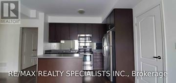 Mississauga (Churchill Meadows) townhouse for rent - A kitchen with dark brown cabinets and stainless steel appliances.
