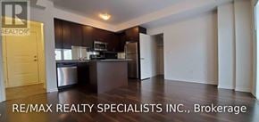 Mississauga (Churchill Meadows) townhouse for rent - A kitchen with dark wood cabinets and a white fridge.