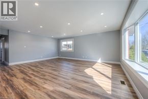 Kitchener apartment for rent - A spacious room with wooden flooring and a large window.