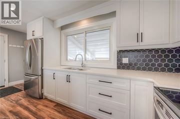 Kitchener apartment for rent - A kitchen with white cabinets and a stainless steel refrigerator.