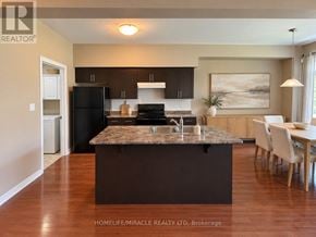 Hamilton (Meadowlands) townhouse for rent - A kitchen with a black refrigerator and brown cabinets.