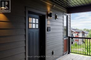 Blue Mountains condo for rent - A black door with a window is on the side of a house.