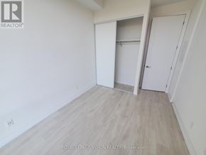 Toronto (Bayview Village) condo for rent - A white room with a wooden floor and a door on the right.