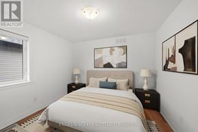 Ottawa apartment for rent - A bedroom with a bed, two nightstands, and a painting on the wall.