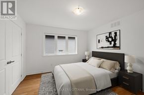 Ottawa apartment for rent - A bedroom with a bed, nightstand, and window.