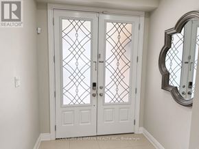 Brampton (Bram West) apartment for rent - A white door with a glass window and a mirror on the wall.