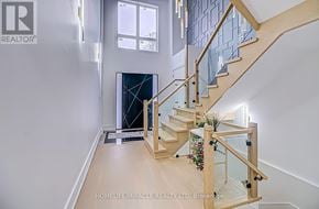 Toronto (Cliffcrest) apartment for rent - A wooden staircase with glass railings leads up to a window.