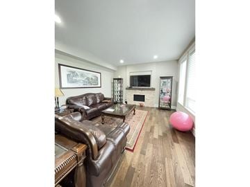 Surrey apartment for rent - A living room with a brown leather couch and a pink exercise ball.