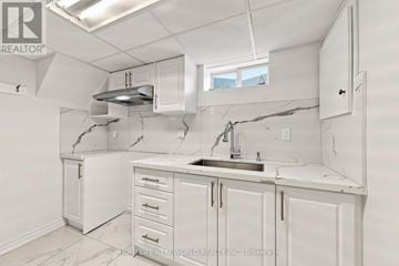 Newmarket (Bristol-London) apartment for rent - A kitchen with white cabinets and a marble countertop.