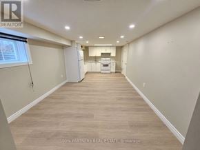 Aurora (Aurora Highlands) apartment for rent - A spacious room with light wood flooring and a kitchenette in the background.