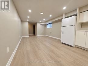 Aurora (Aurora Highlands) apartment for rent - A spacious room with a white refrigerator and wooden flooring.