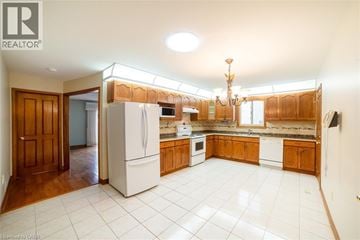 Hamilton apartment for rent - A kitchen with white appliances and wooden cabinets.