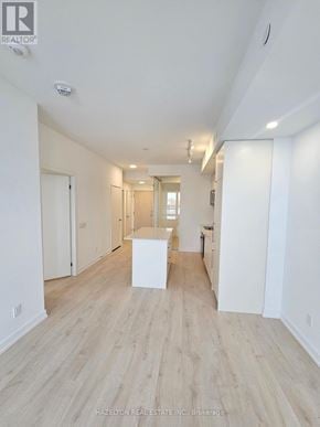 Toronto (Willowdale East) condo for rent - A real estate listing photo of a white interior space with wood flooring and a white reception desk.