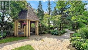 Toronto (Willowdale East) condo for rent - A gazebo is surrounded by a brick walkway and greenery.