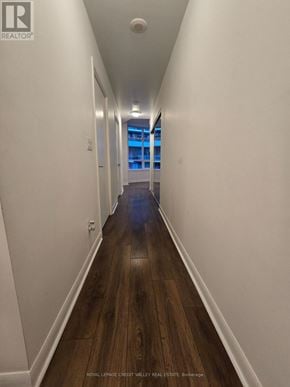 Toronto (Niagara) condo for rent - A long hallway with wood floors and white walls.