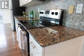 Toronto (Niagara) condo for rent - A kitchen with a granite countertop and white appliances.