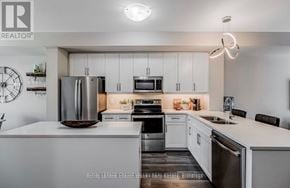 Brantford townhouse for rent - A modern kitchen with white cabinets and stainless steel appliances.