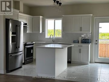 Lakeshore apartment for rent - A kitchen with white cabinets and a large island.