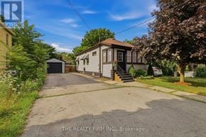 London East (East G) apartment for rent - A house with a driveway and a sign that says "The Realty Firm Inc., Brokerage".