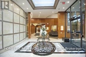 Toronto (Lansing-Westgate) condo for rent - A foyer with a glass door and a table with a vase of flowers on it.