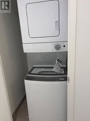 Mississauga (Lakeview) condo for rent - A white washing machine with a grey top and a grey door is in a small room.