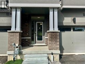 Brant (Brantford Twp) townhouse for rent - A house entrance with a glass door and a sign that says RE/MAX REALTY SPECIALISTS.