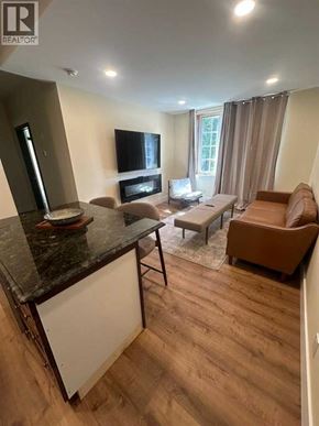 Blairmore apartment for rent - A living room with a black countertop and a brown sofa.