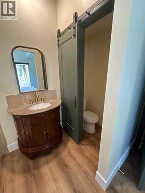 Blairmore apartment for rent - A bathroom with a sink, toilet and a wooden cabinet.