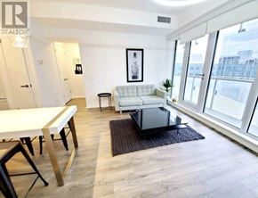 Toronto (Church-Yonge Corridor) condo for rent - A living room with a white couch, a black coffee table, and a framed picture on the wall.