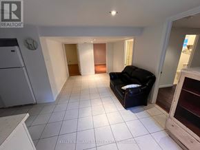 Toronto (Birchcliffe-Cliffside) apartment for rent - A living room with a black couch and a white refrigerator.
