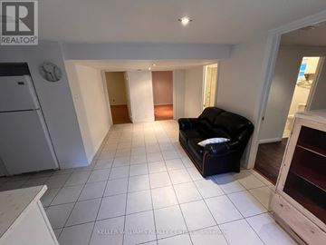 Toronto (Birchcliffe-Cliffside) apartment for rent - A living room with a black couch and a white refrigerator.