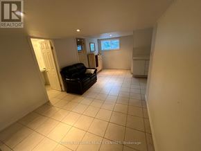 Toronto (Birchcliffe-Cliffside) apartment for rent - A spacious living room with a black sofa and a window.