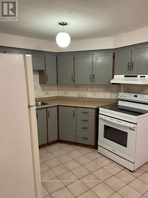 Mississauga (East Credit) apartment for rent - A kitchen with white appliances and grey cabinets.