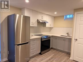 Brampton (Heart Lake West) apartment for rent - A kitchen with a stainless steel refrigerator and white cabinets.